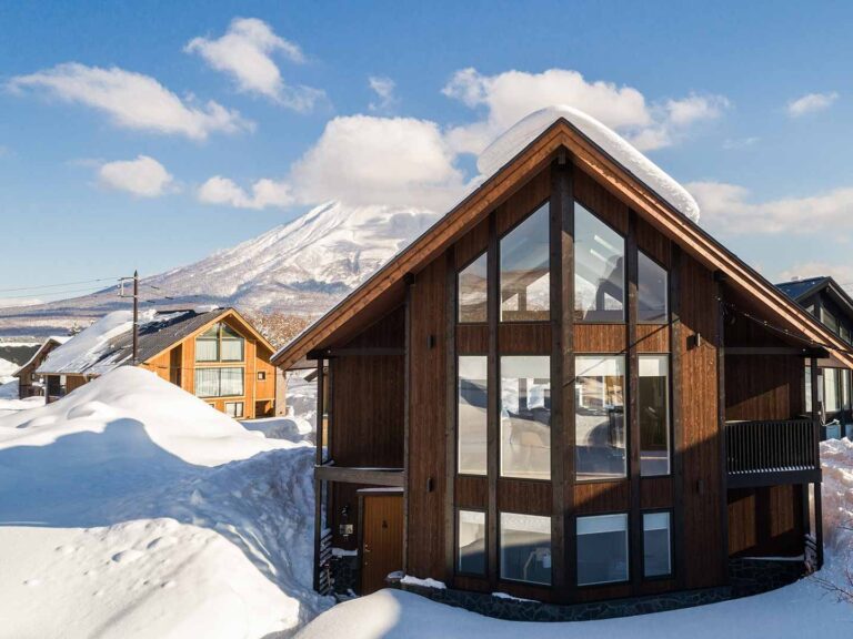 The Orchards Niseko luxury chalet with snow-covered roof and Mt. Yotei in the background — accommodation for the Women on Edge ski-treat.