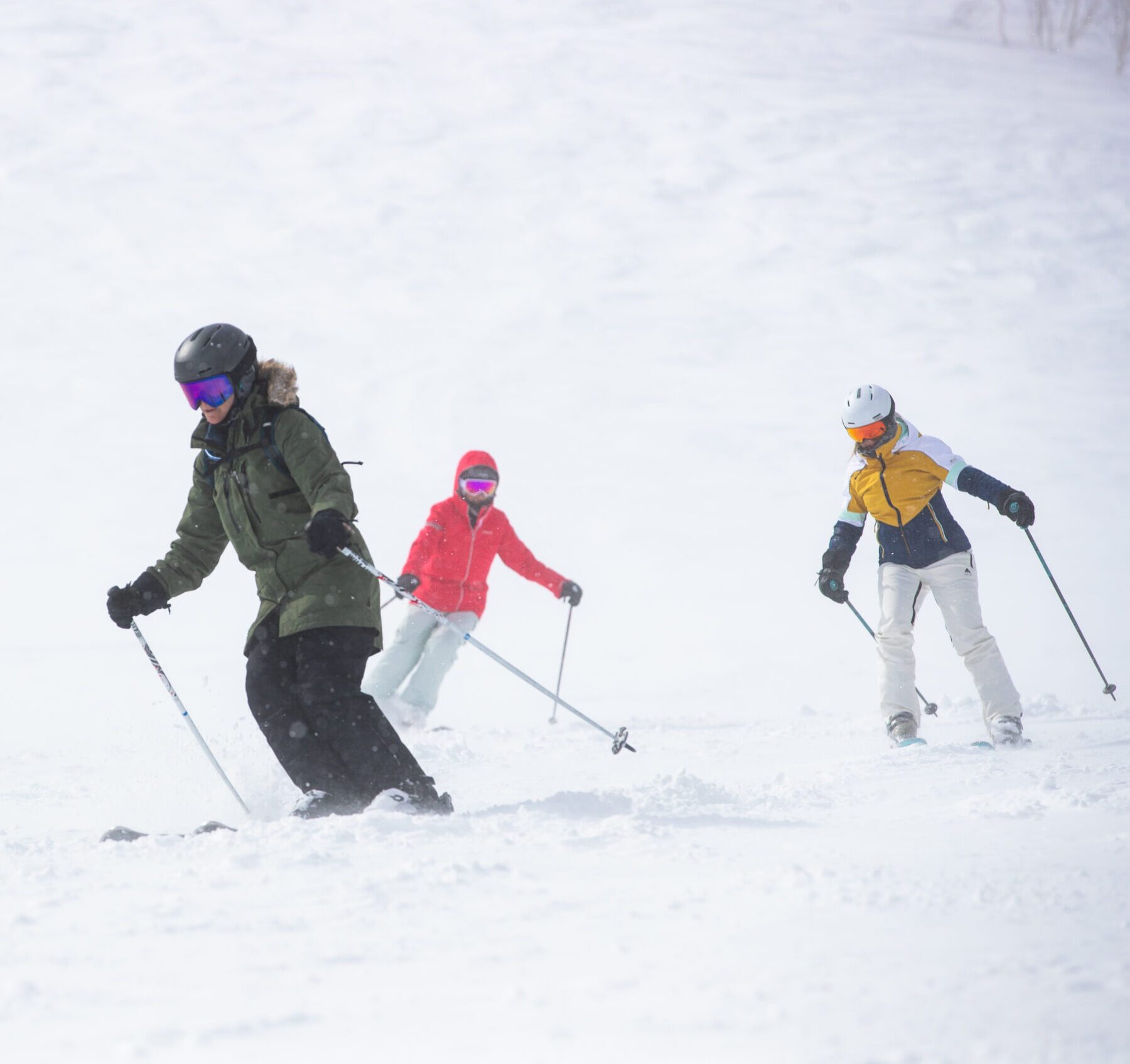 Intermediate women skiers carving turns in Niseko, Japan during a Women on Edge ski-treat week.